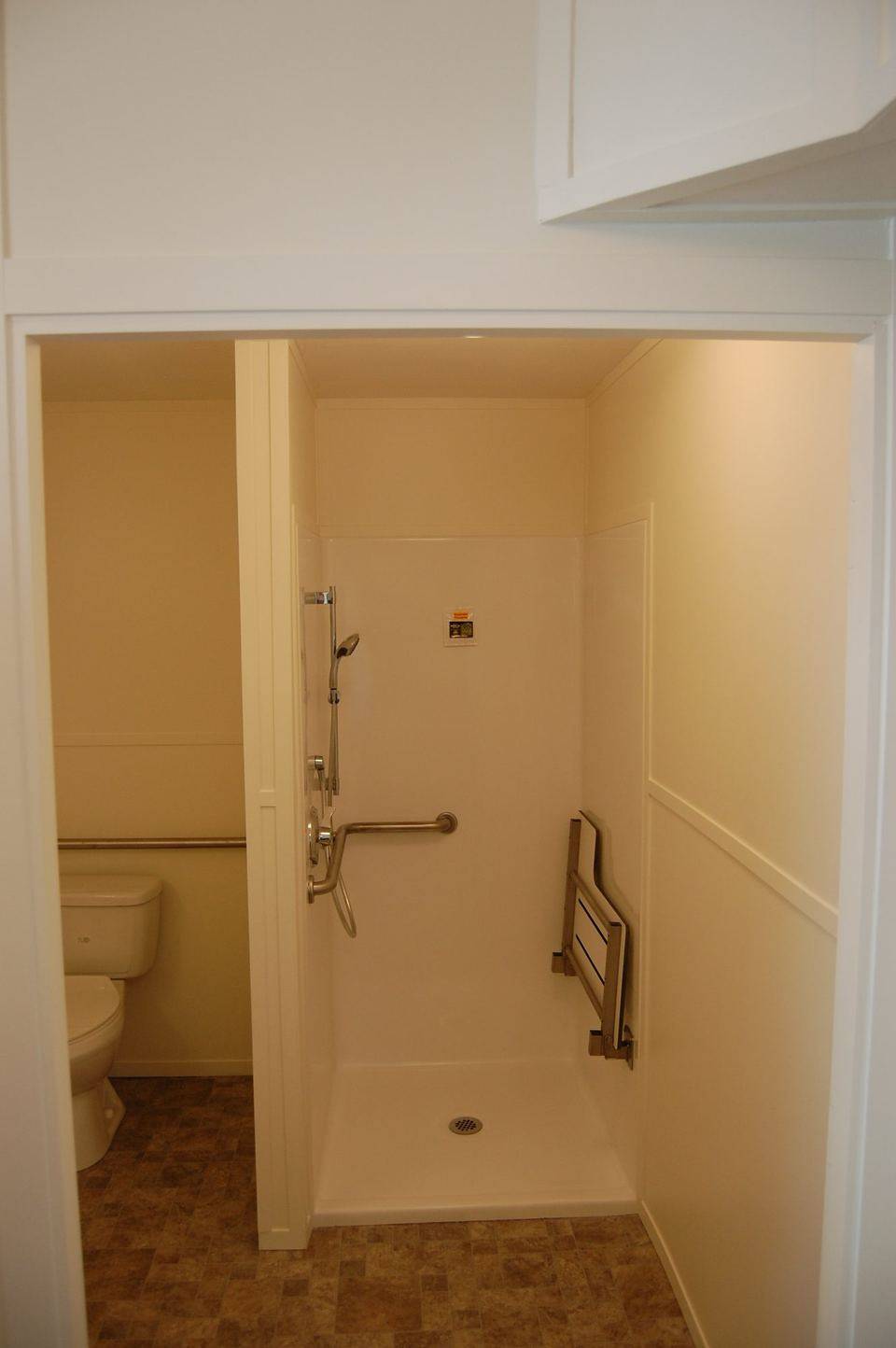 Accessible bathroom with grab bars and fold-down shower seat
