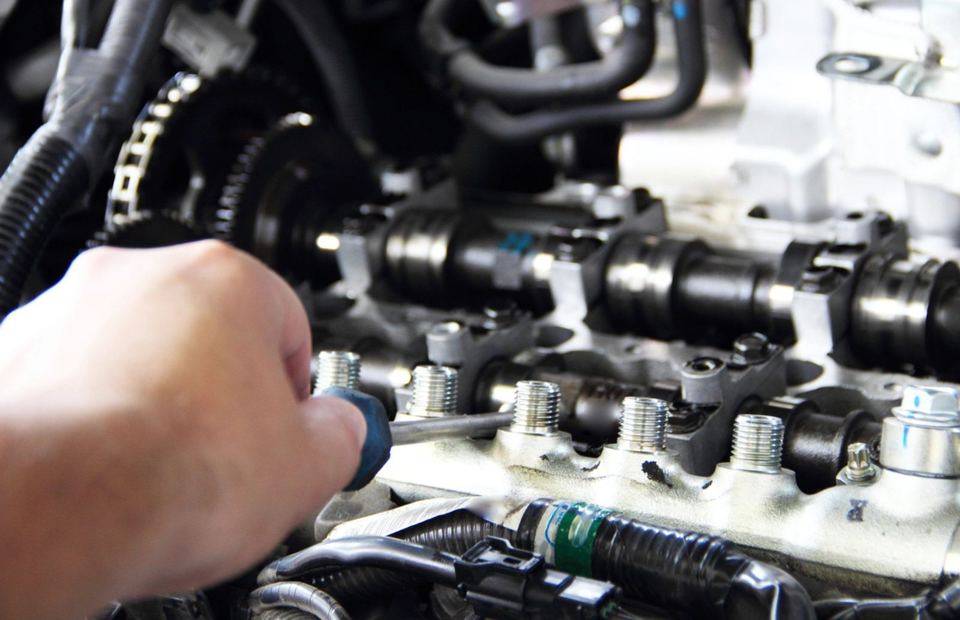 Hands working on a vehicle engine