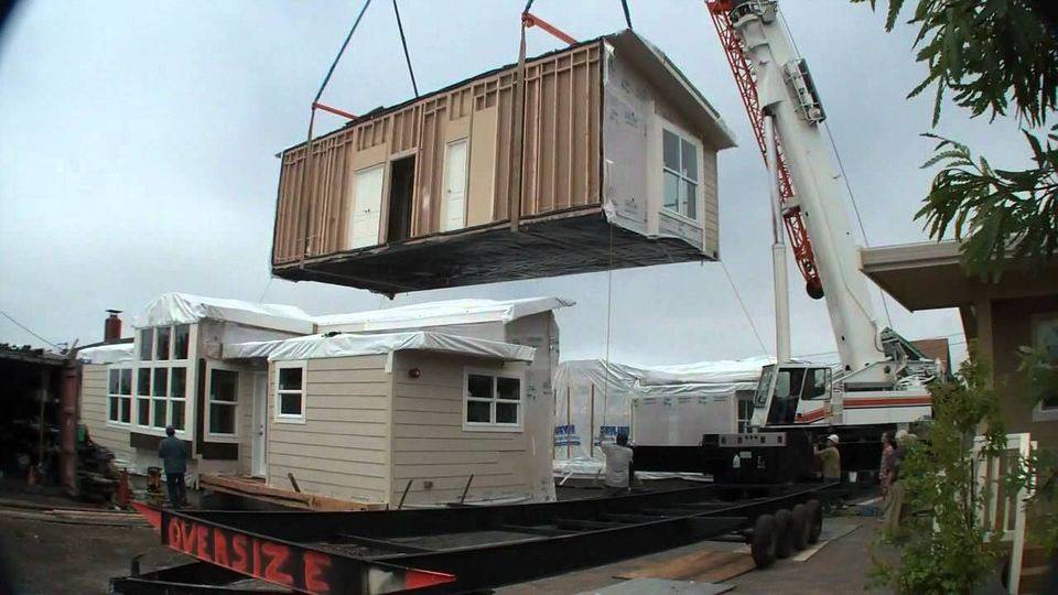 Modular home section being lifted by crane