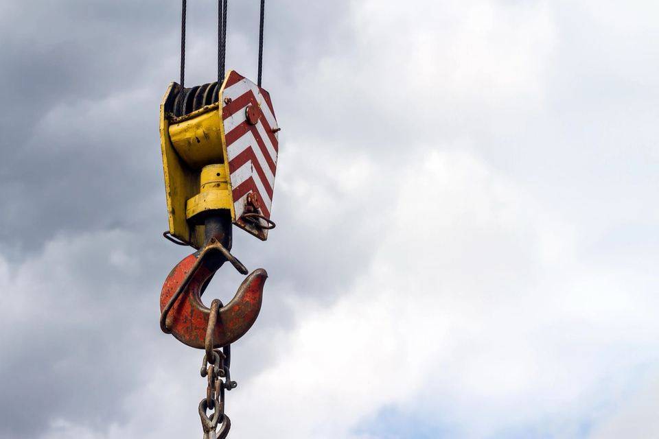 Crane hook against a cloudy sky