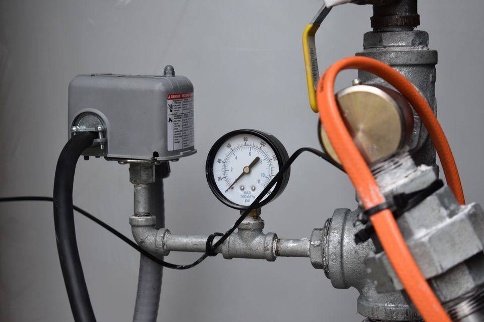 Pipe assembly with a pressure gauge and orange hose